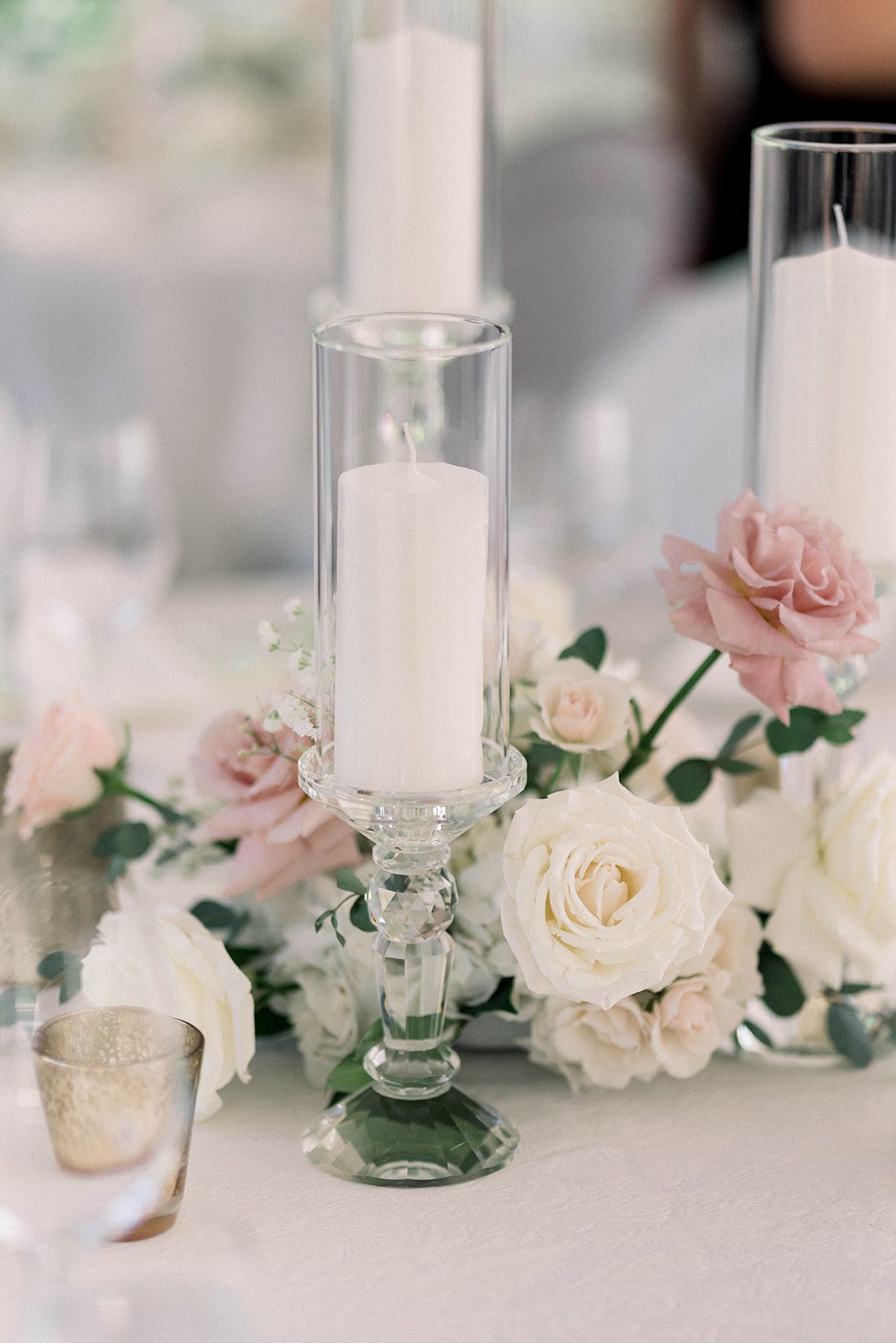 White pillar candles cozy up to pink and white flowers at Hart Hart wedding reception 