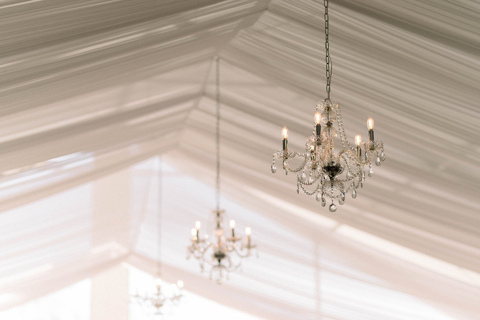 Crystal chandeliers hang from Hart House for wedding reception. 
