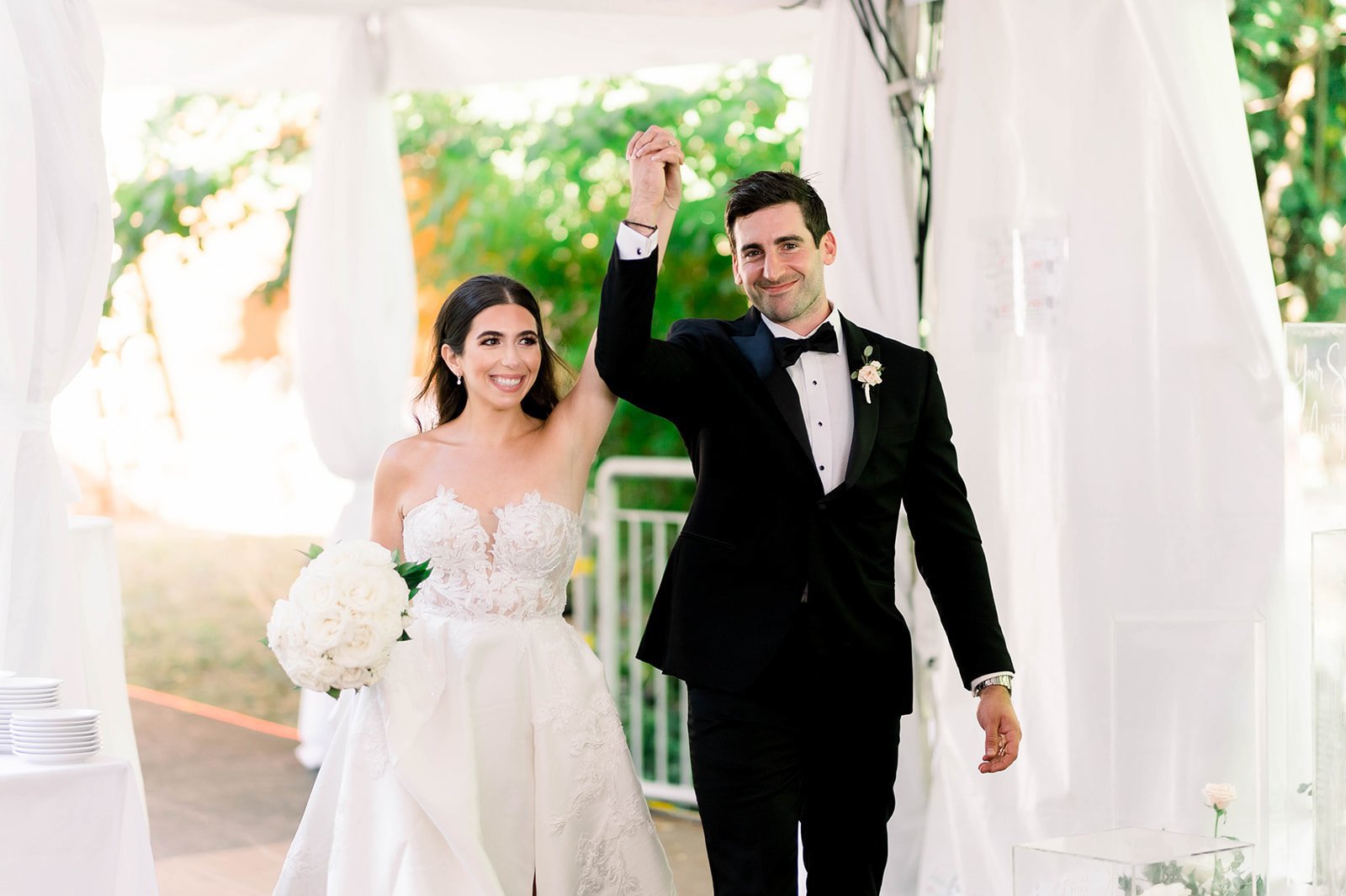 Bride and Groom enter Hart house triumphantly, clasped hands raised as if they just won a wrestling match.  