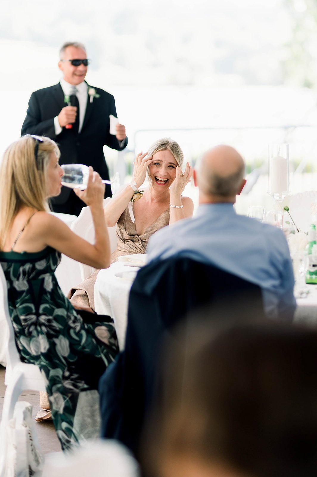Wedding guests laugh merrily during dinner at a Hart House wedding reception.