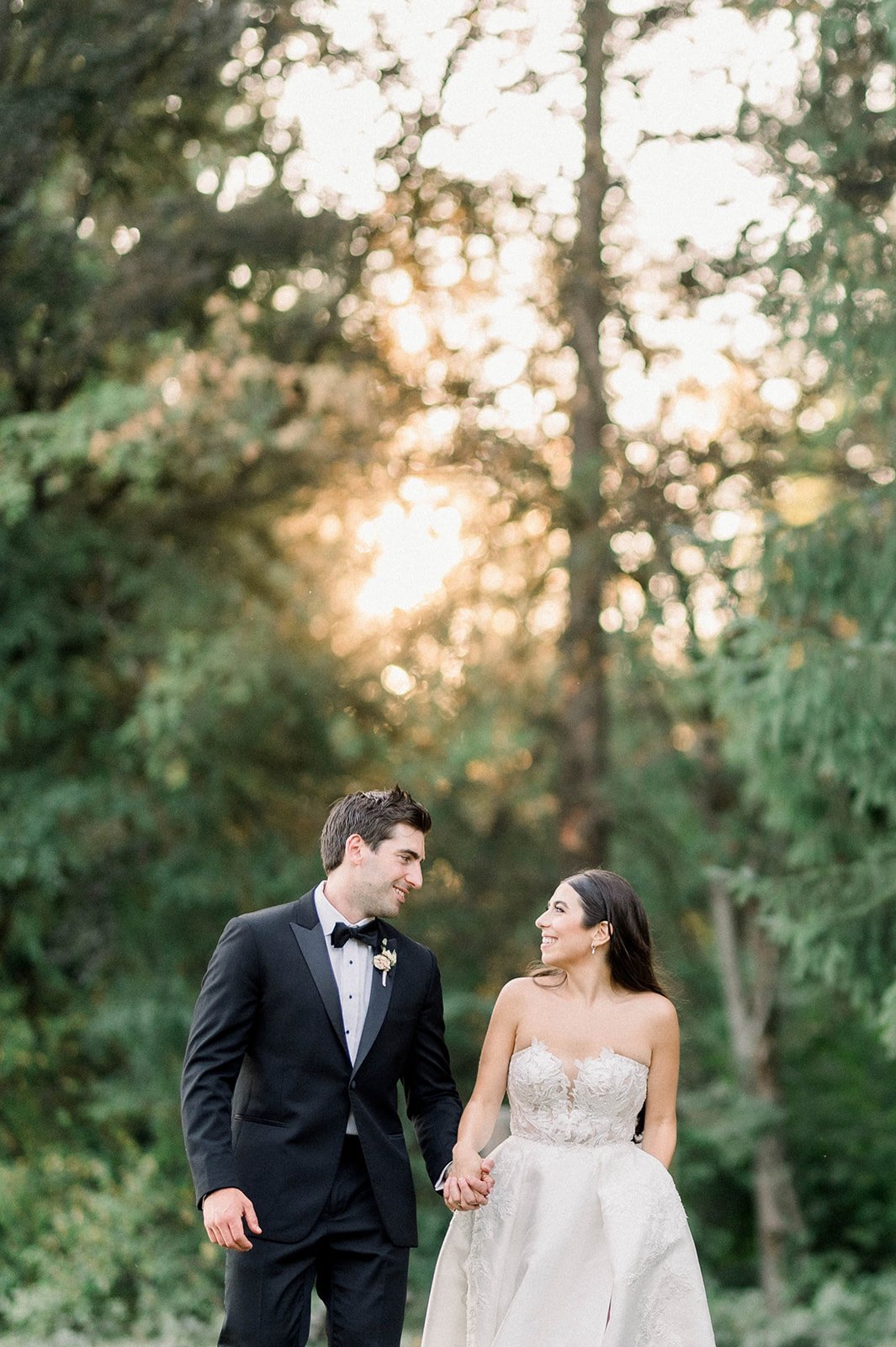 Bride and groom take a sunset stroll though trees at Hart House in Vancouver BC.