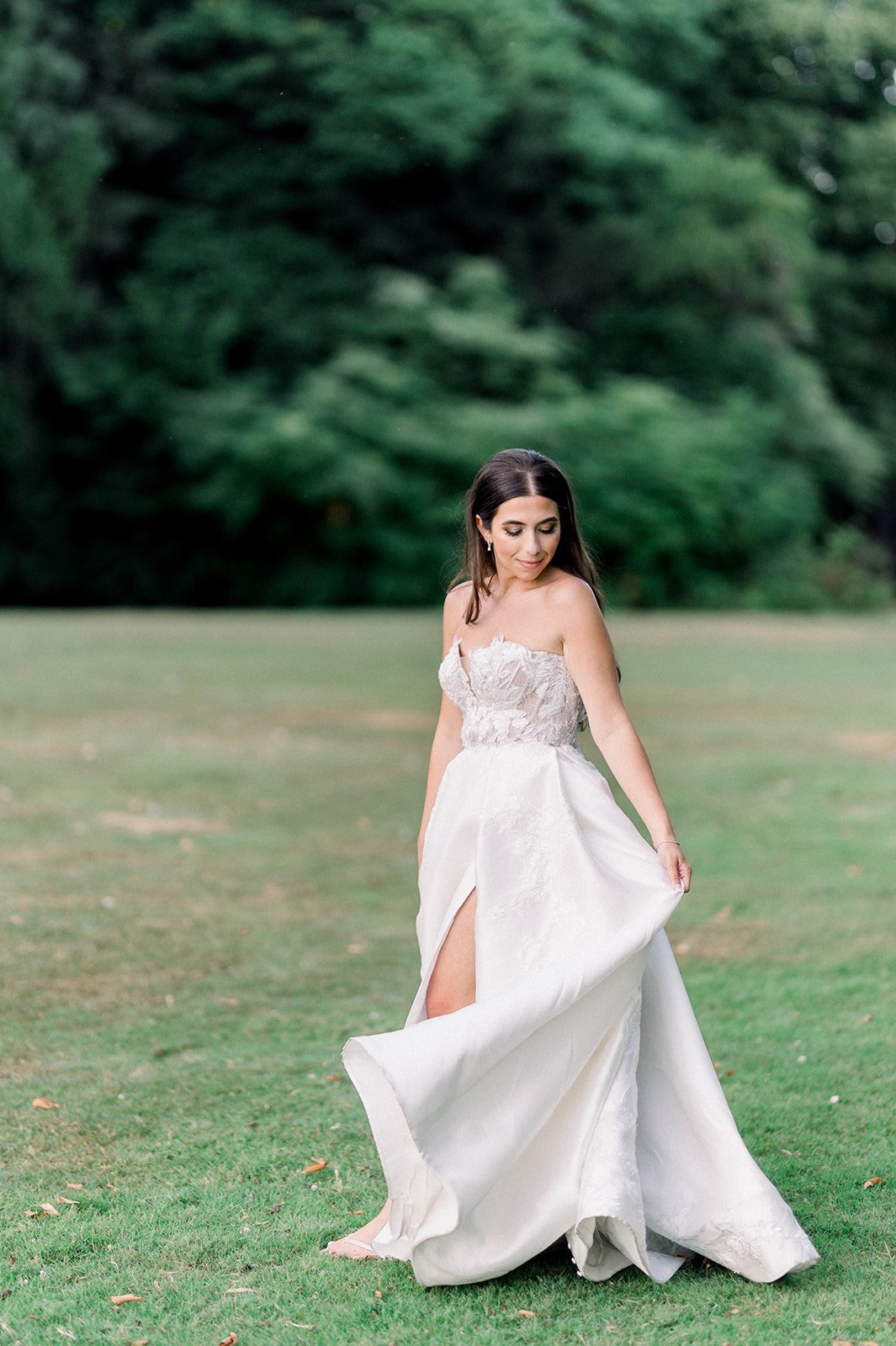 Bride twirls in ballgown on grassy field at Hart House in Vancouver, BC.