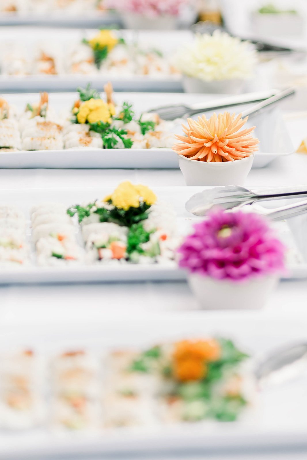 Purple and Orange flowers separate sushi platters at Punjabi Sikh wedding. 