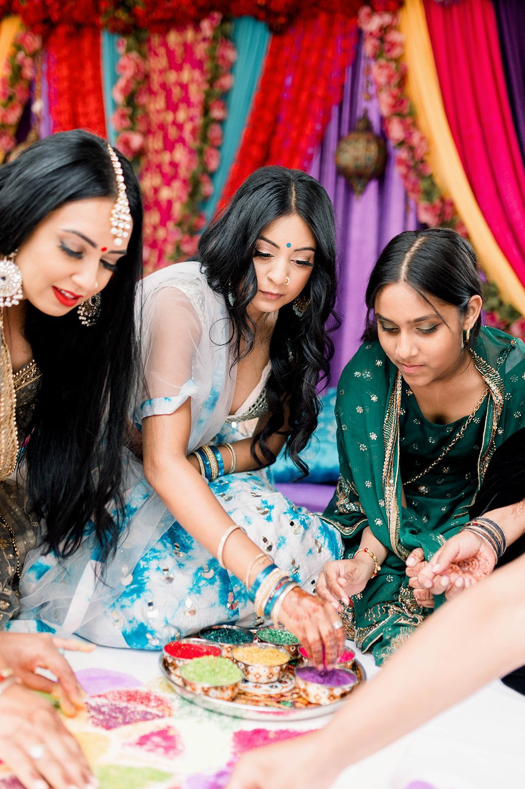 Sister of the bride places colourful rice on mayian rangoli in Victoria, BC 