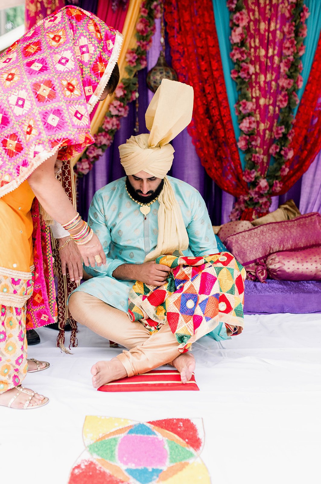 Groom sits on stool as he begins his mayian ceremony for his south Asian wedding.