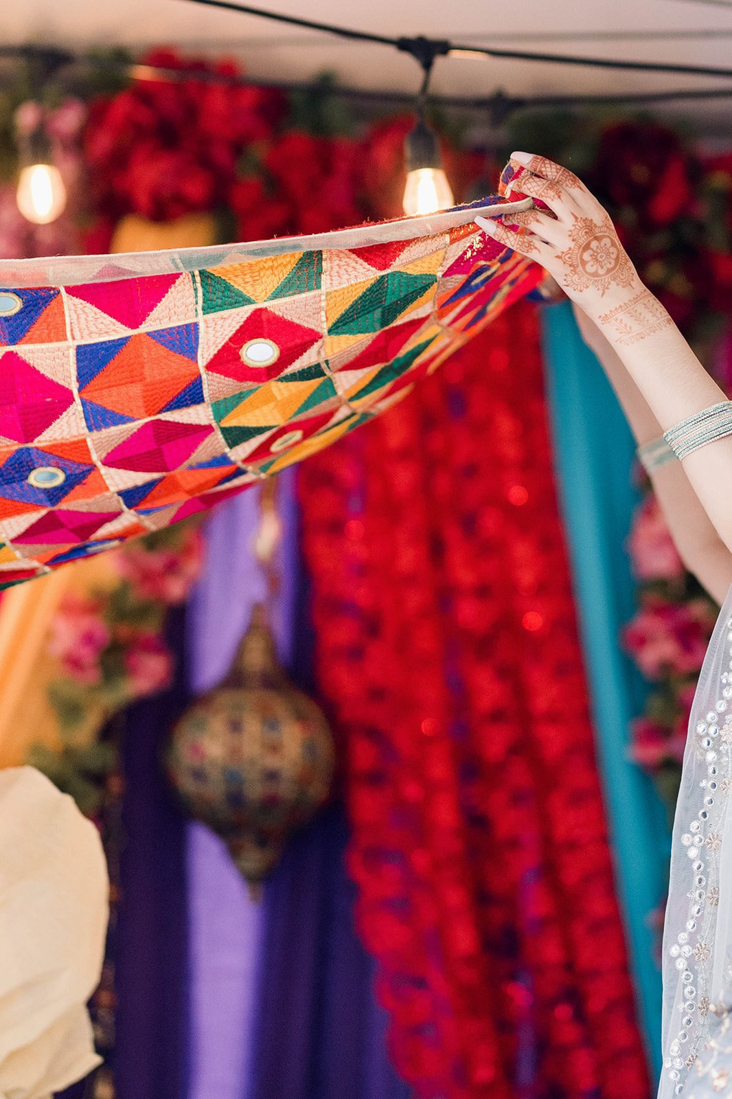 Colorful chunni is held above bride for Mayian Ceremony.