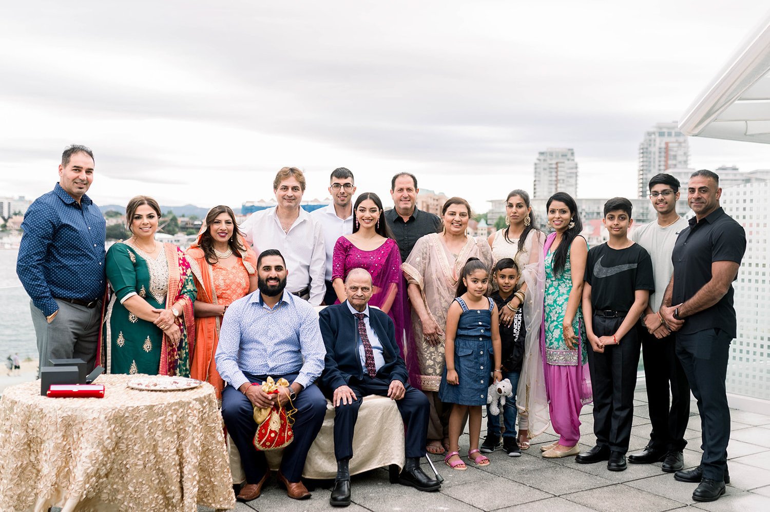 A Indian groom's large family gathers around him as he poses for a group photo during his Indian Wedding.