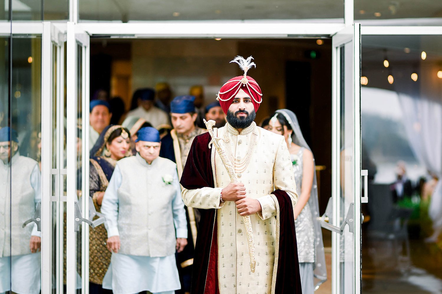A indian groom clutches a kirpan as he enters his Sikh Ceremony 