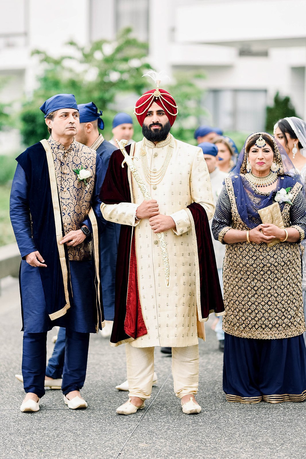 An indian groom in a red turban and cream coat prays before his wedding ceremony in Victoria BC 