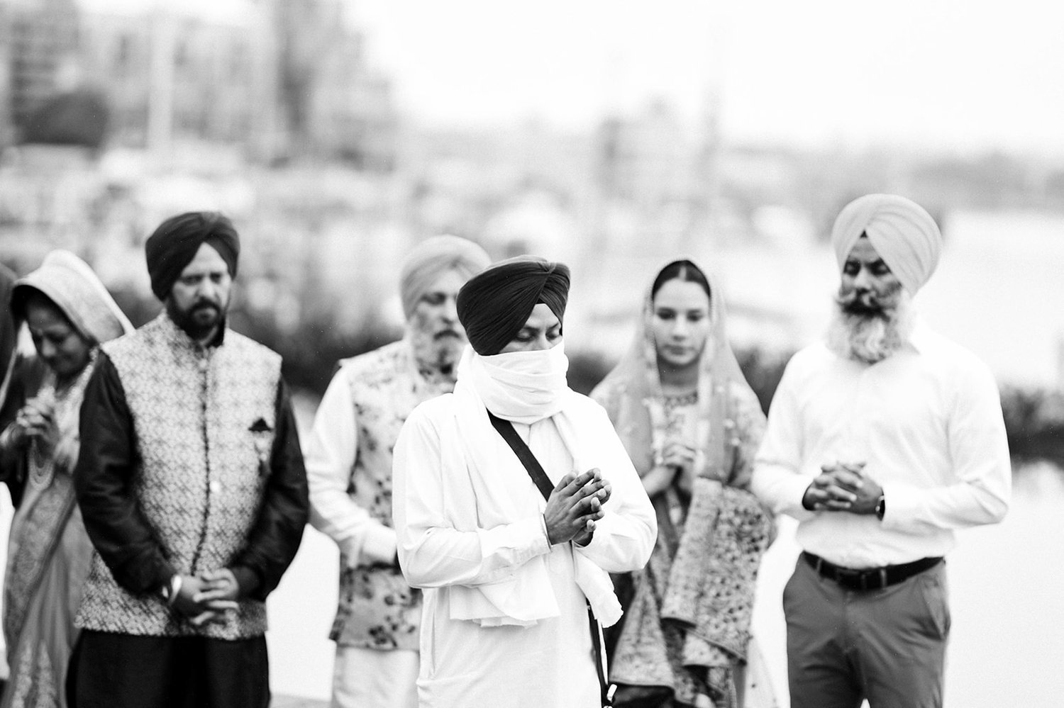 A Priest leads the groom and his family in a prayer before a Sikh wedding in Victoria BC 