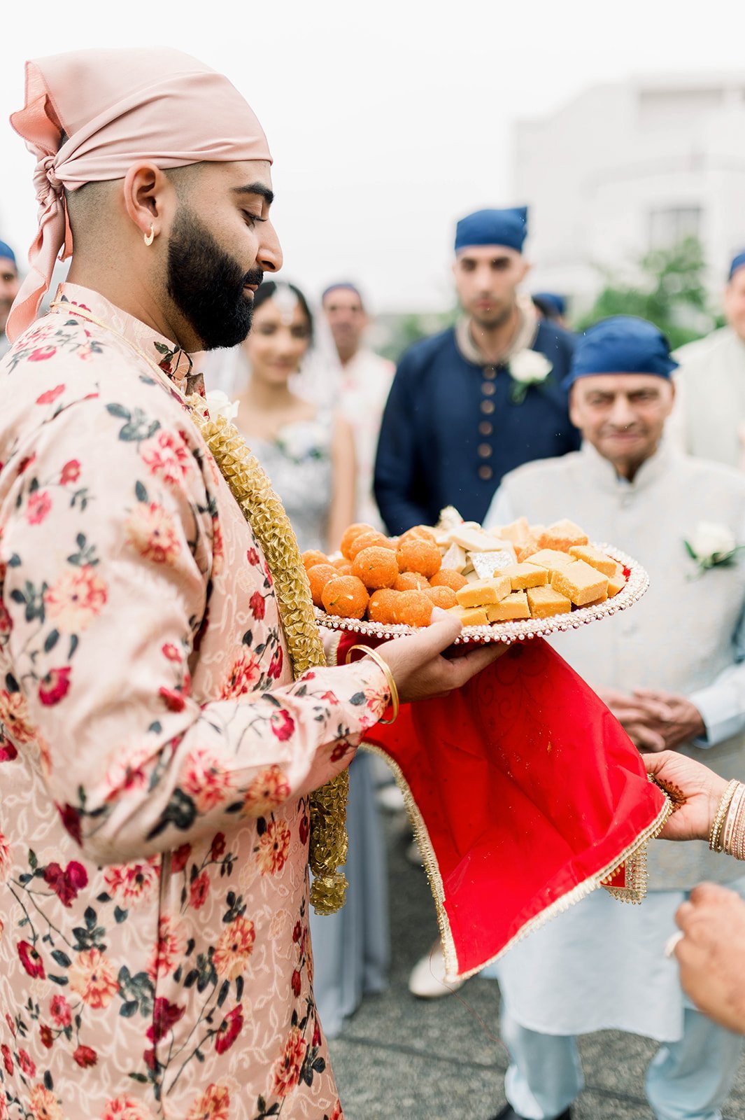 The Brides brother offer's food to the grooms family after a milni ceremony