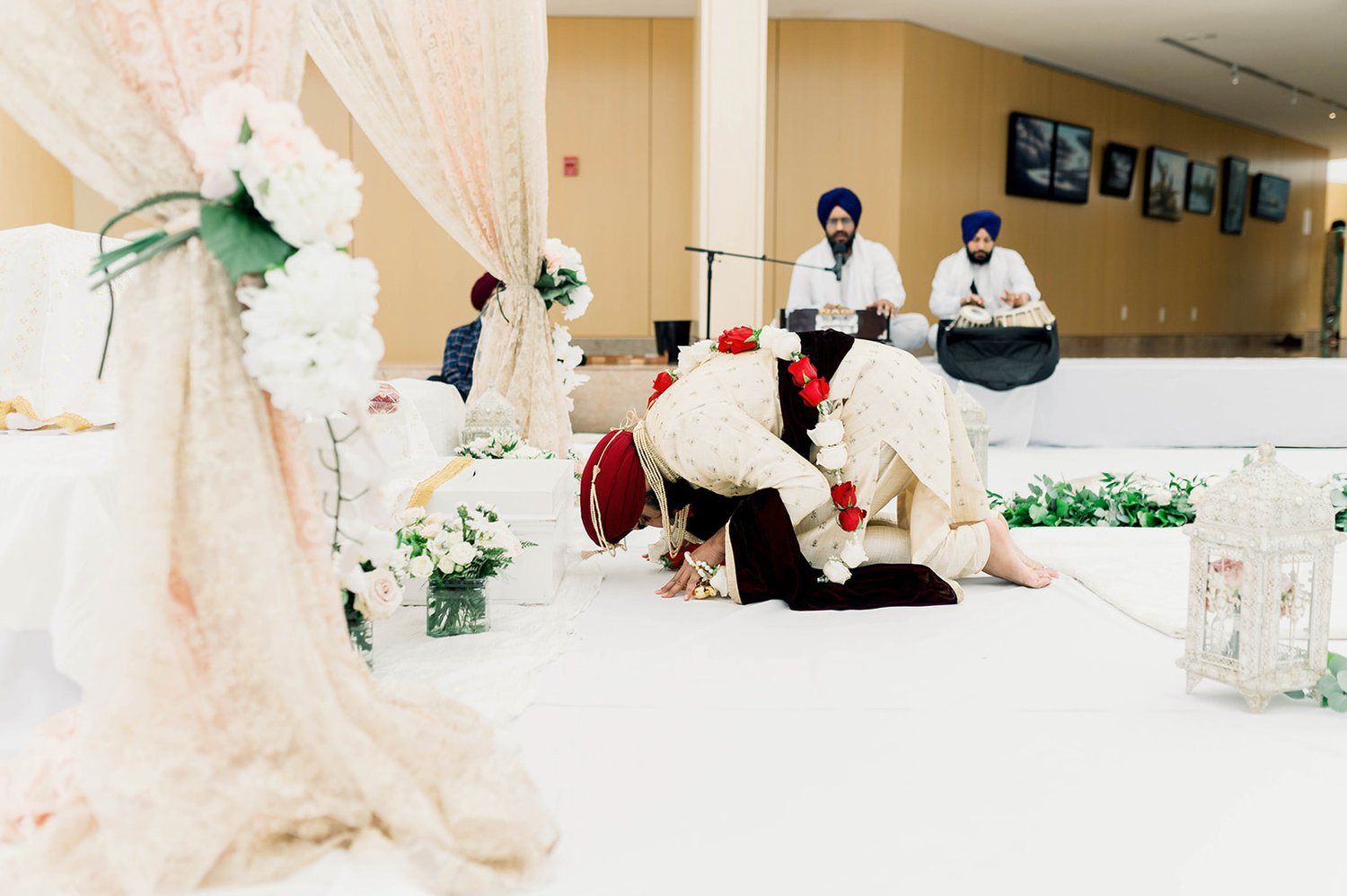 An indian groom bows to the guru before his wedding