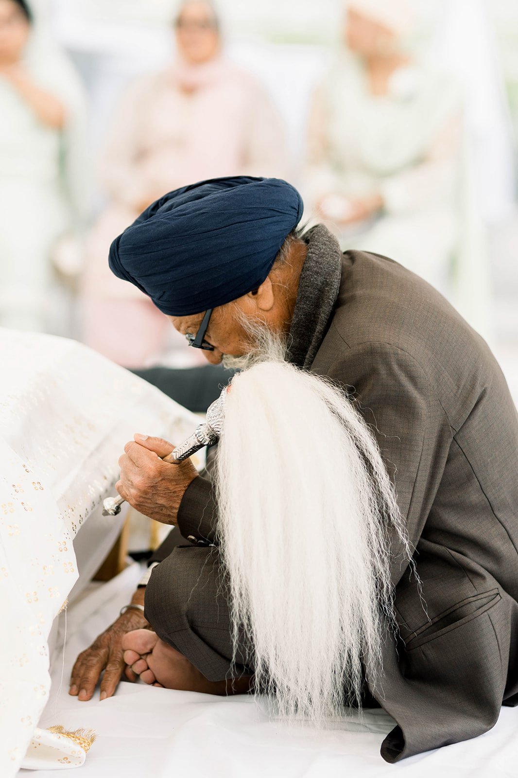 A priest sits on a alter before a Indian Punjabi wedding in victoria BC 