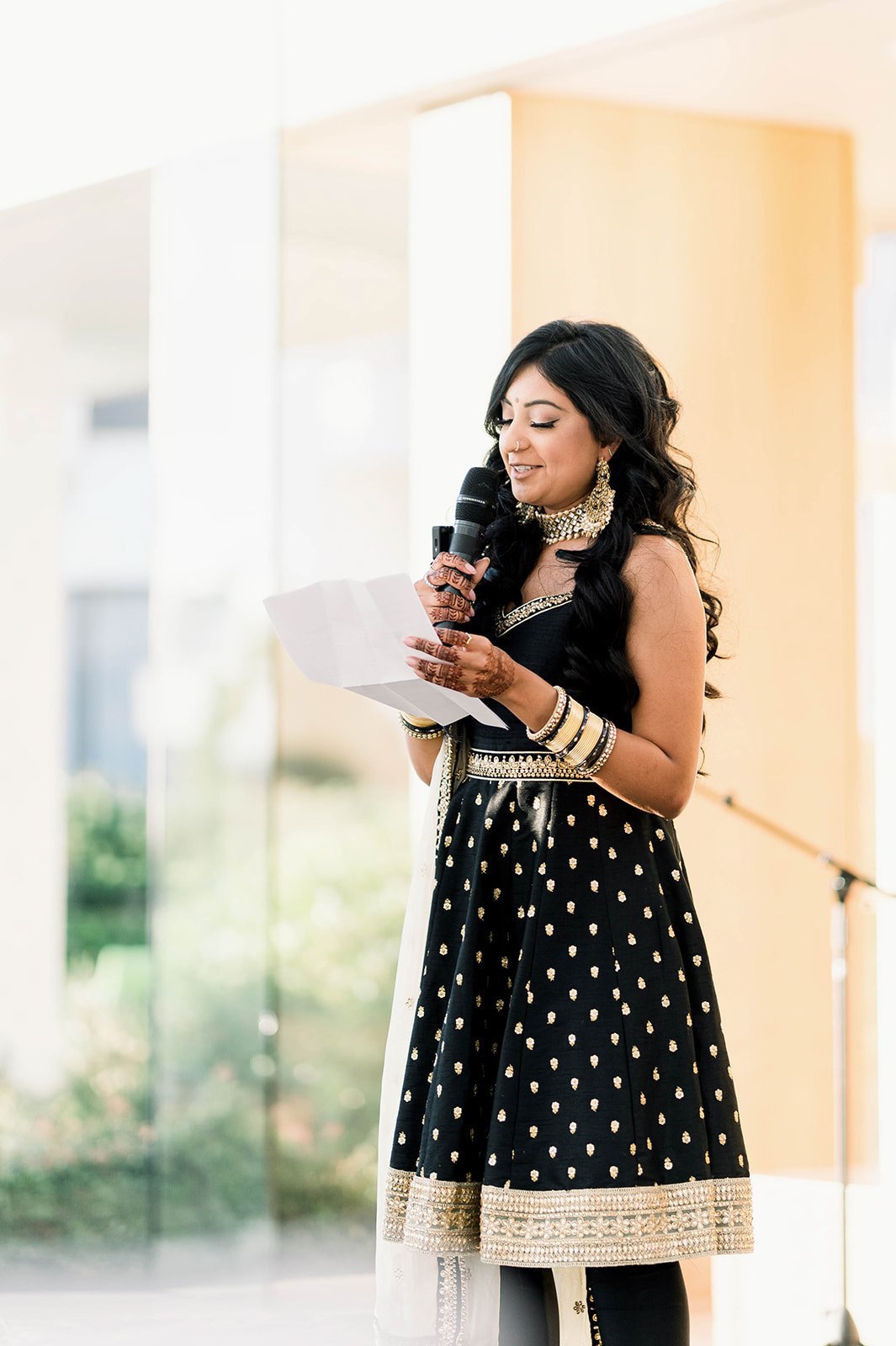 A women in a black tunic gives a speech at a reception in Victoria BC 