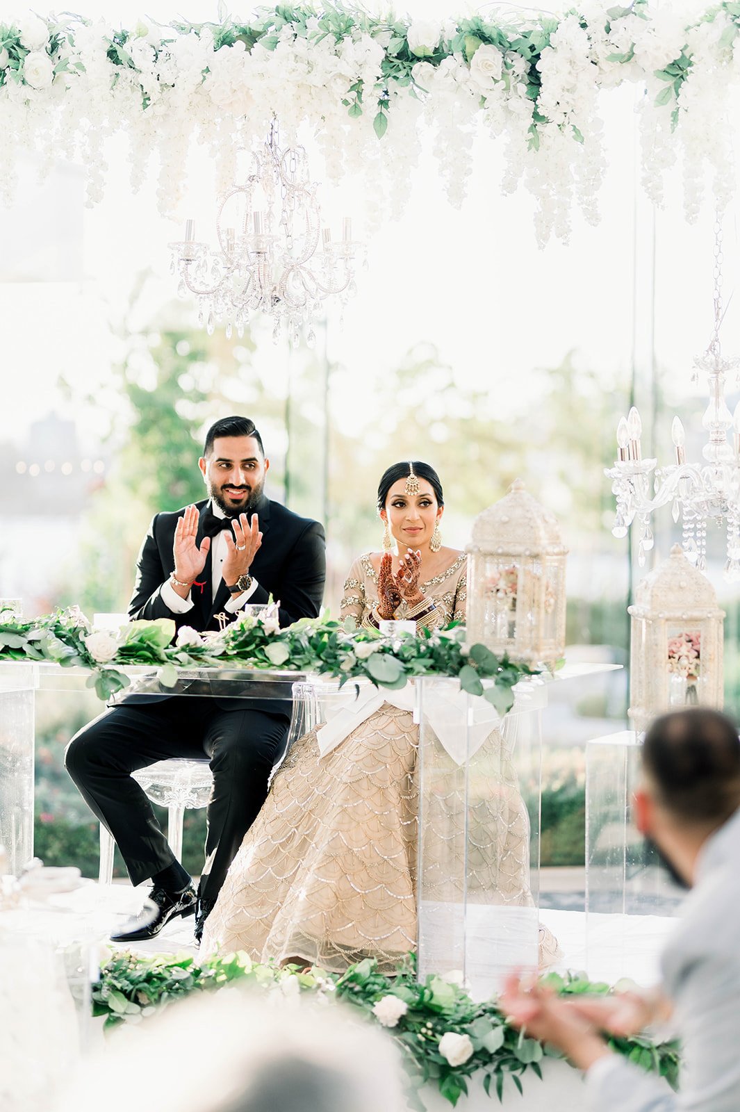 A bride and groom clap during a speech at their reception in Victoria BC