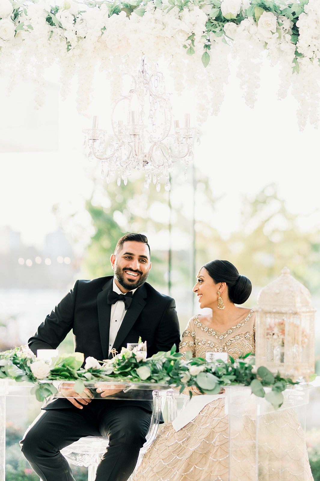 An Indian bride and groom smile and laugh at each other during their reception in Victoria BC