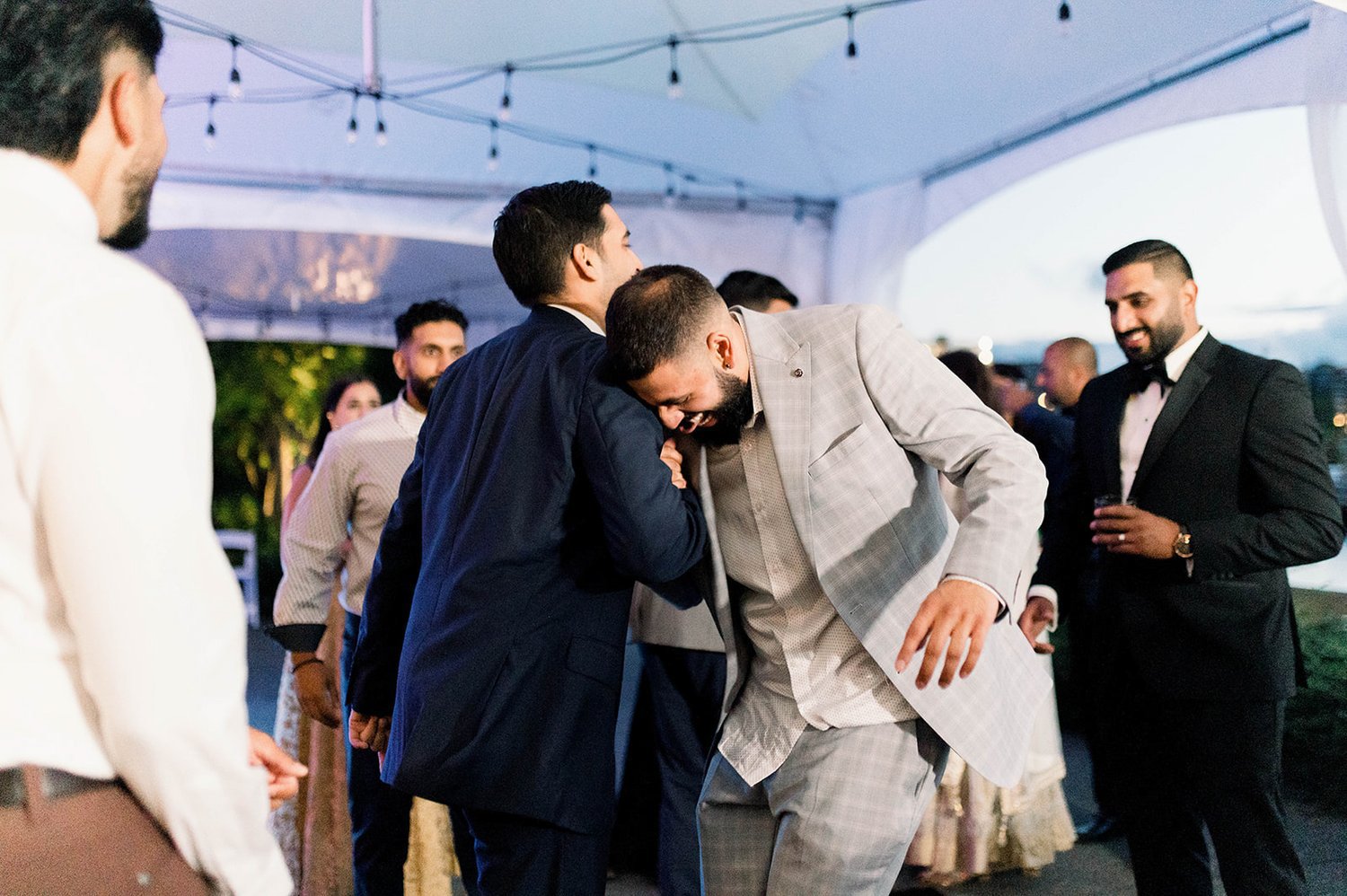 Two Bros shake hands on the dancefloor of a wedding reception in Victoria BC 