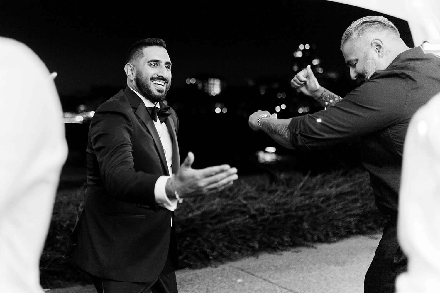A black and white photo of a groom dancing at his reception.