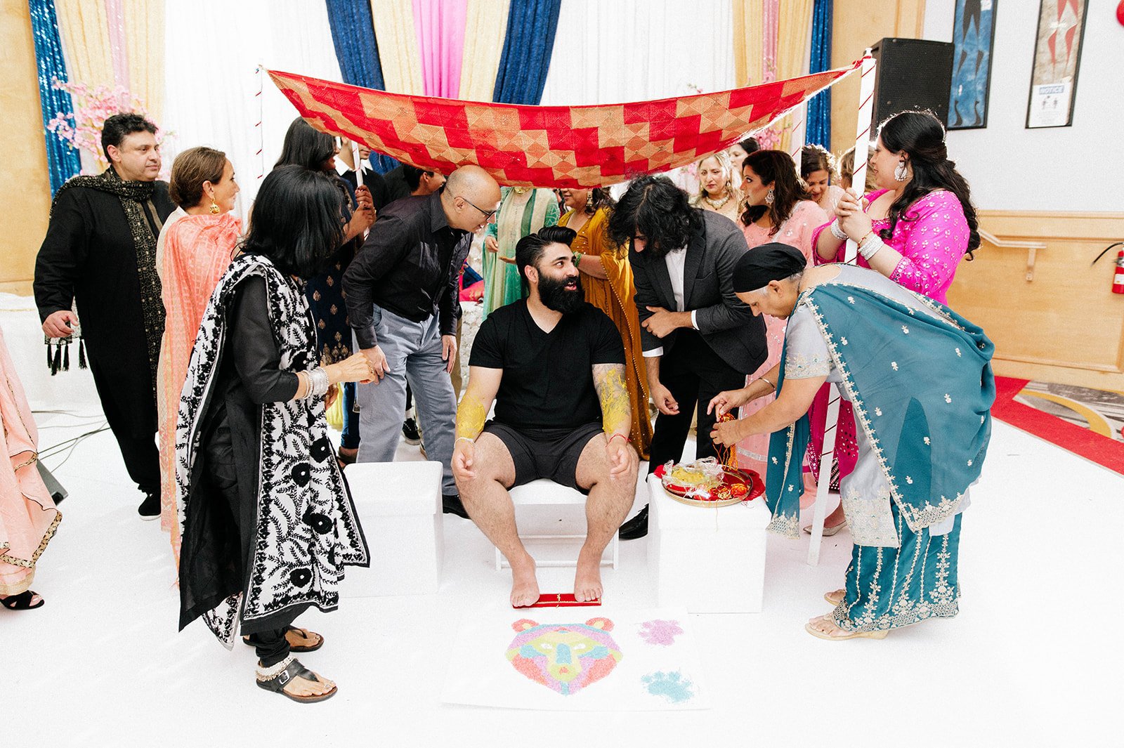 An indian groom smiles during his mayian ceremony with his family