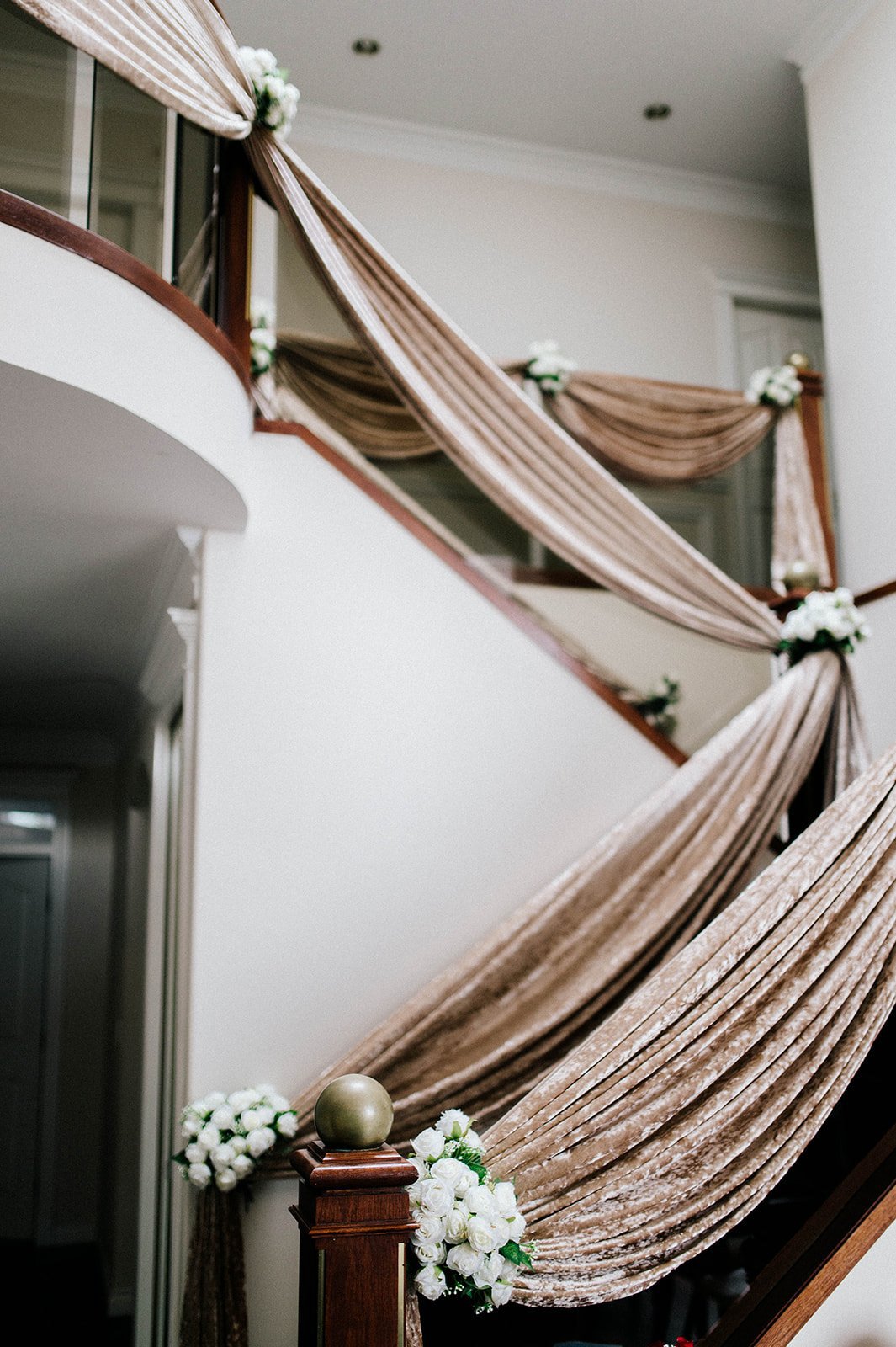 Bridal decorations and fabric drape a banister in the bride's home