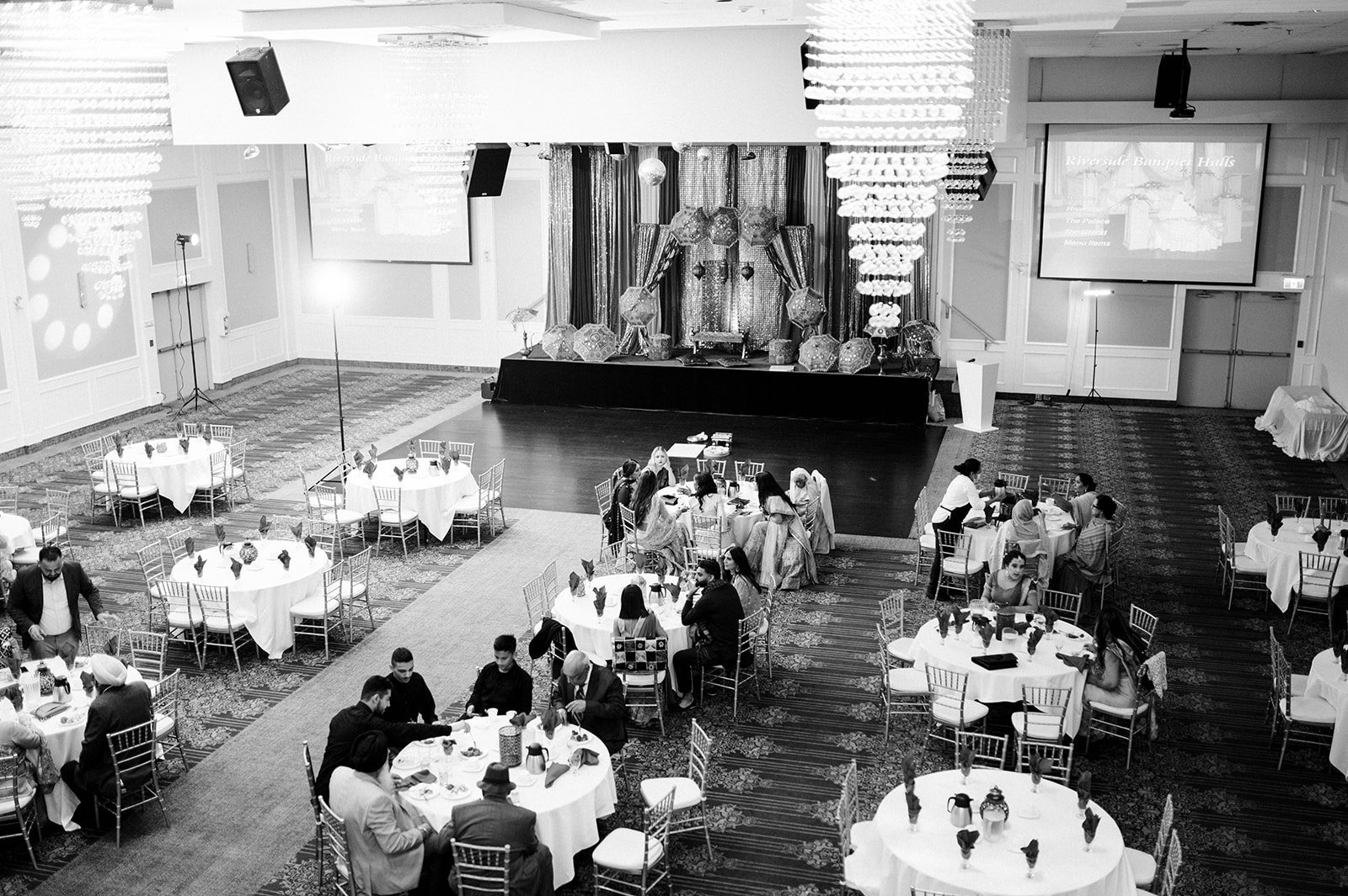 A black and white wide shot of a banquet hall for a maiyan
