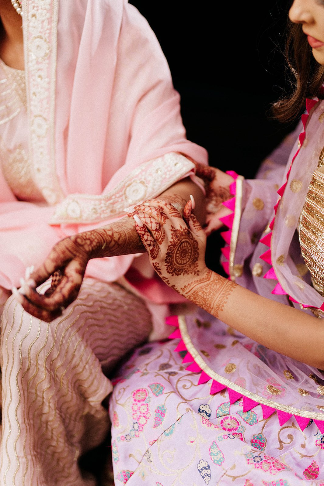 A close up arm of an indian bride as she has yellow turmeric paste to her arm in Surrey BC 