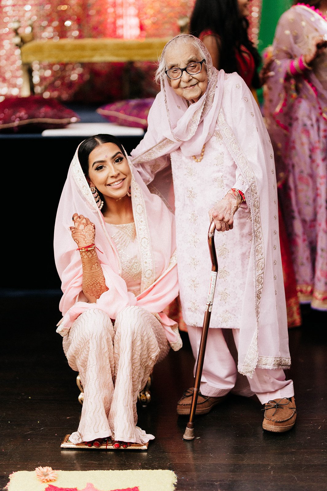 A bride and her grandmother smile at the camera during her Maiyan ceremony