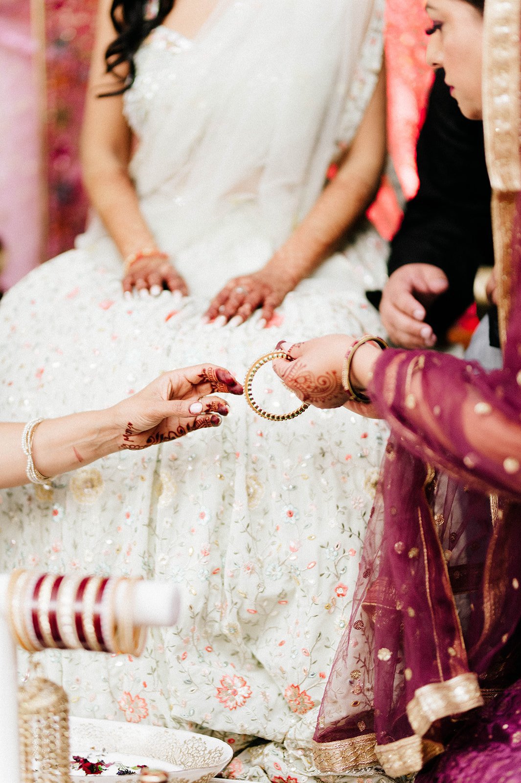 A bride receives colourful red bangles in a traditional ceremony