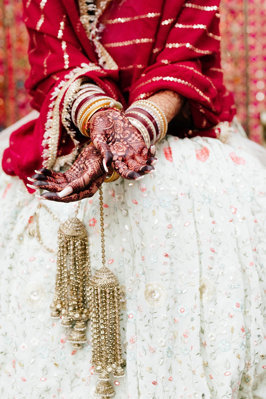 Gold ornaments dangle from henna encrusted hands in surrey BC  