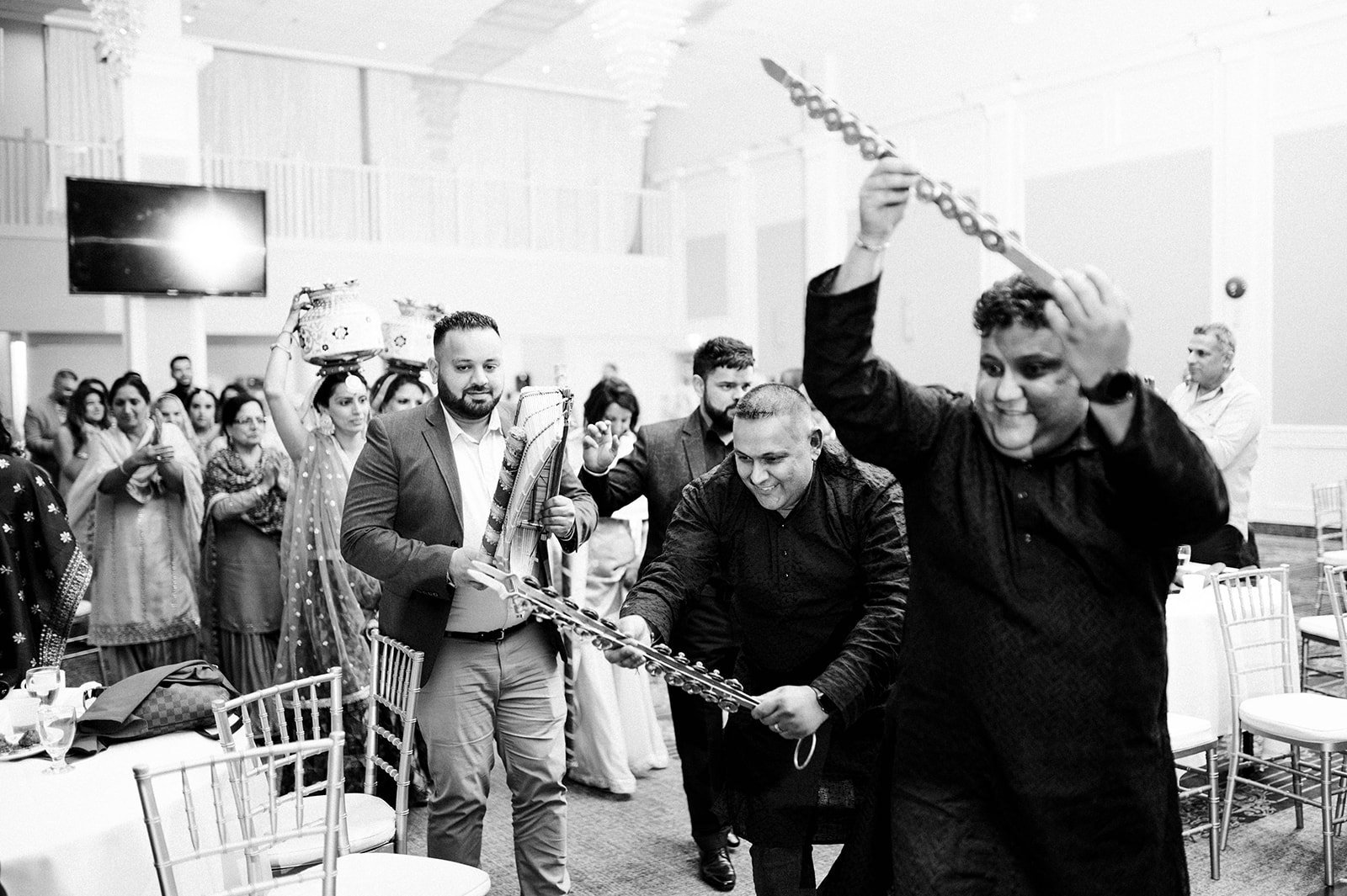 Uncles dance with traditional instruments in a jaggo ceremony in surrey BC 