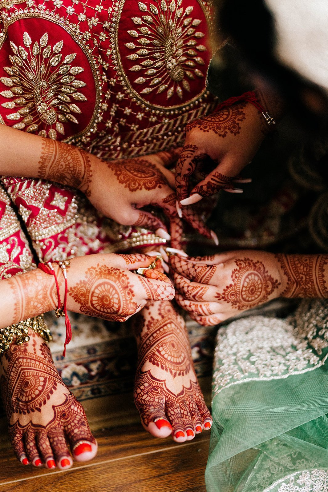 A anklet is put around a brides ankle by her friends.