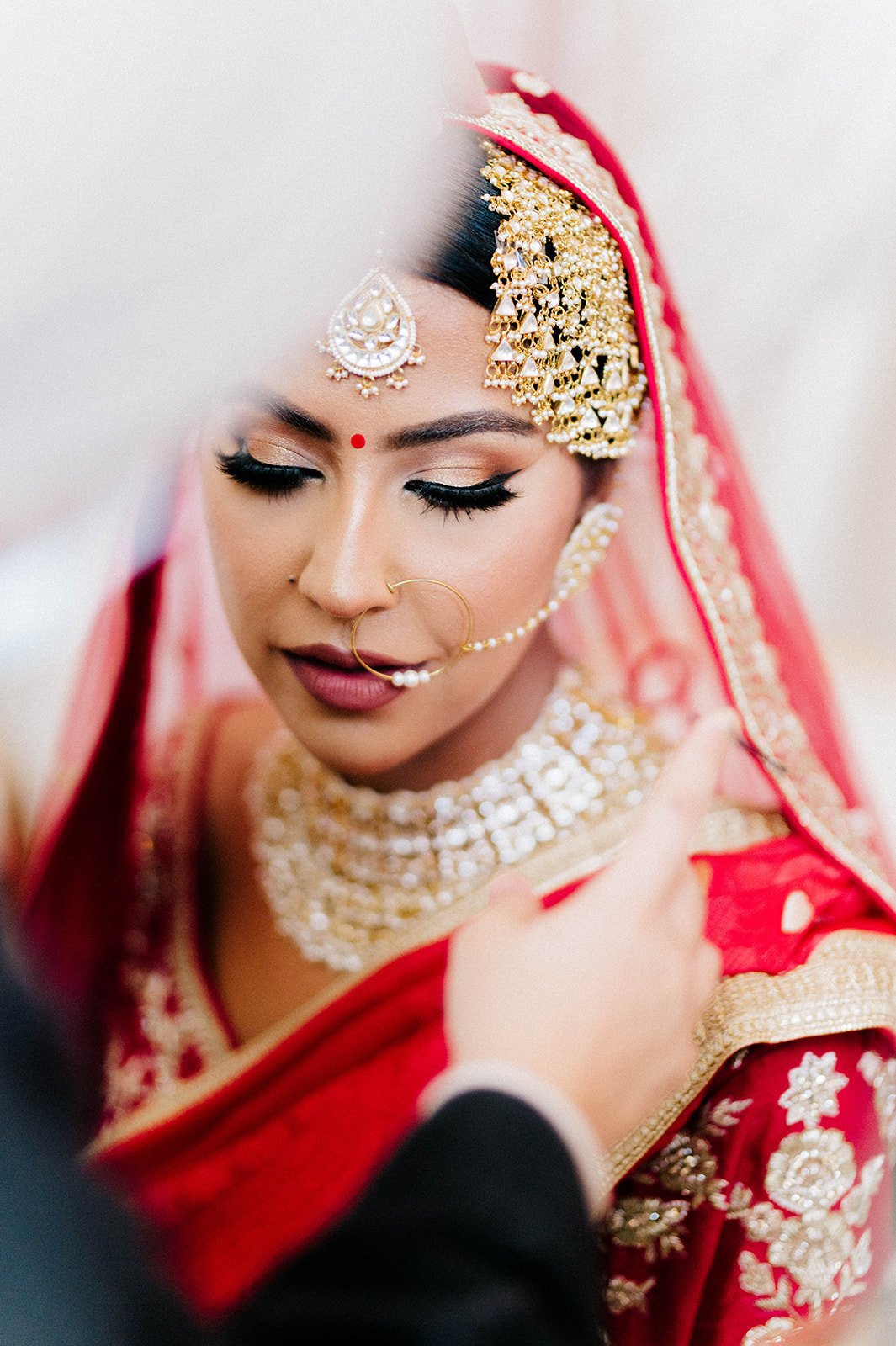 An indian brides parents place a chunni on their daughters head in Surrey BC 