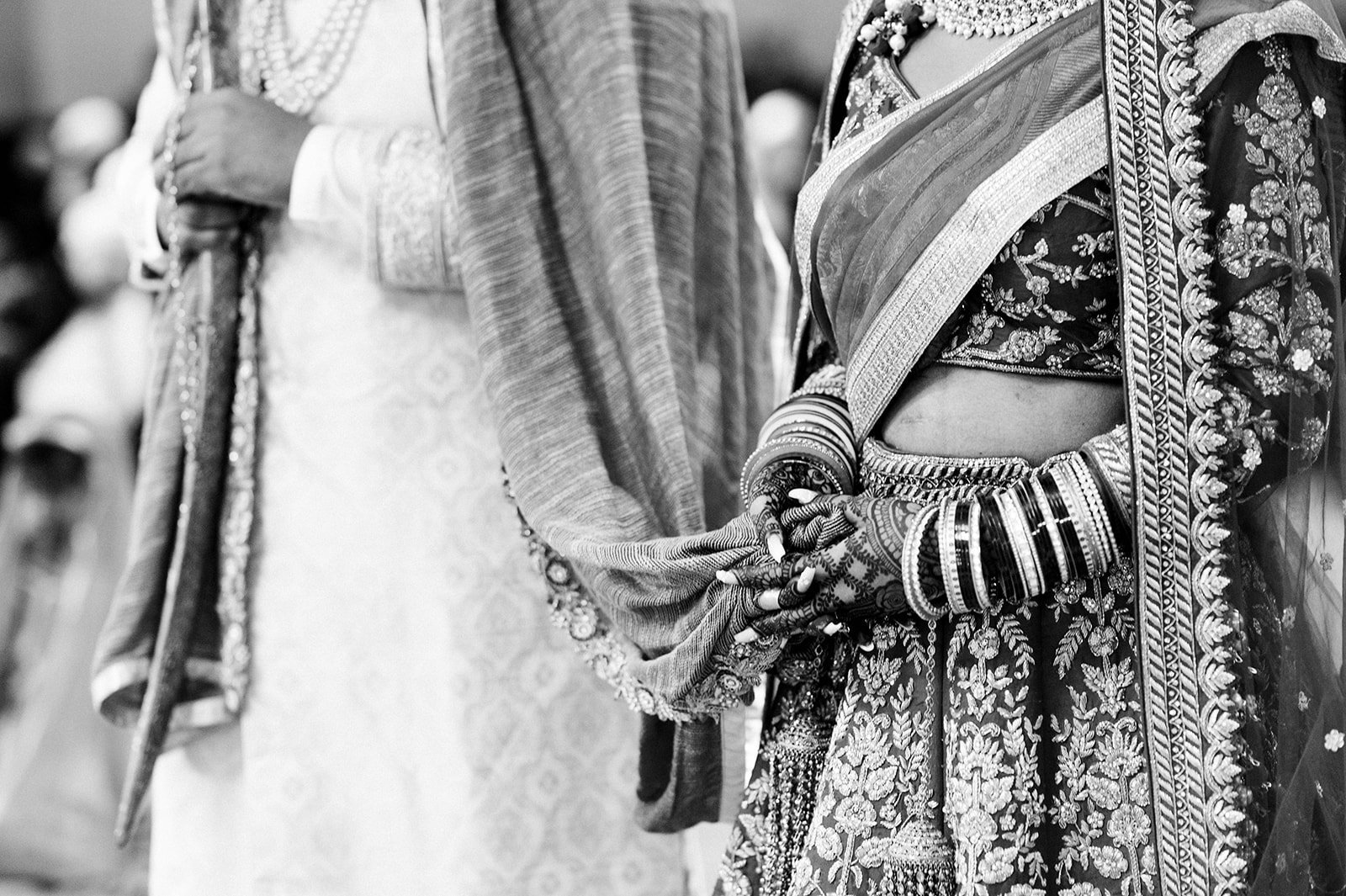 An indian bride holds the grooms pala shawl during their wedding ceremony.