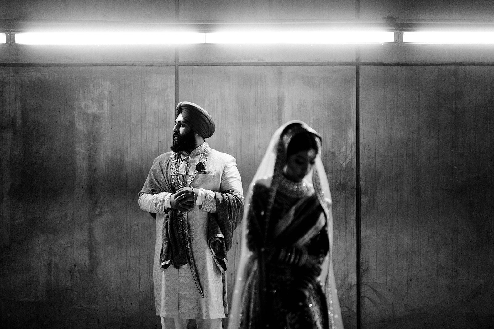 An Indian couple pose in a cinematic backlit photo in a tunnel under vancouver, BC. 