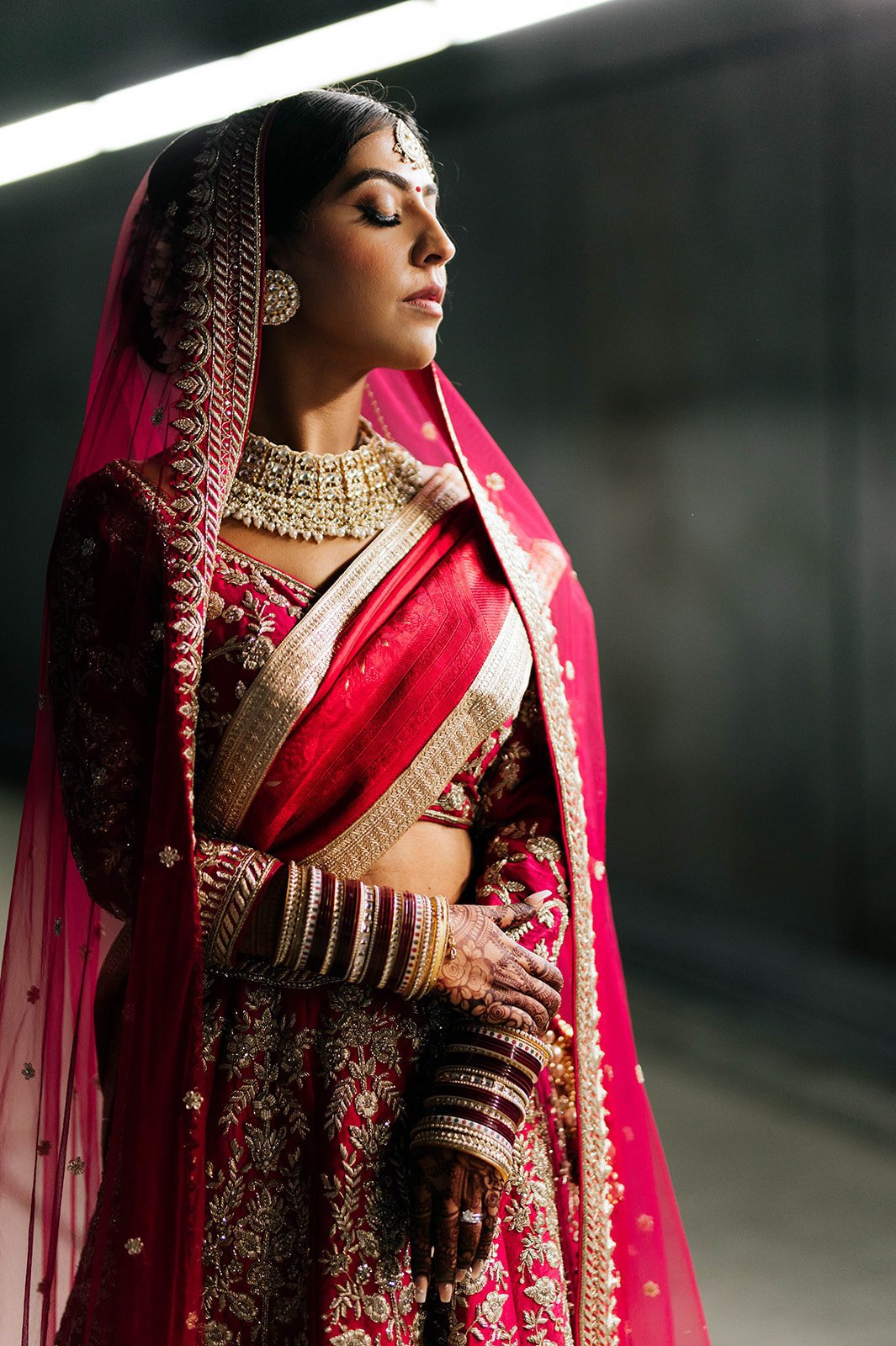 An Indian bride poses in a cinematic backlit photo in a tunnel under vancouver, BC. 