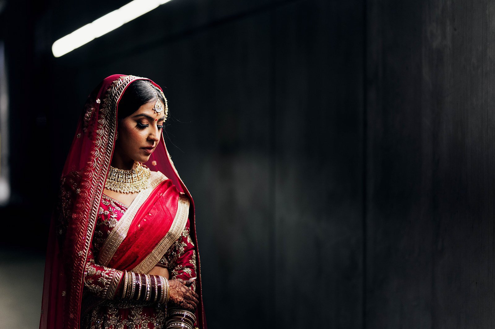 An Indian bride poses in a cinematic backlit photo in a tunnel under vancouver, BC. 