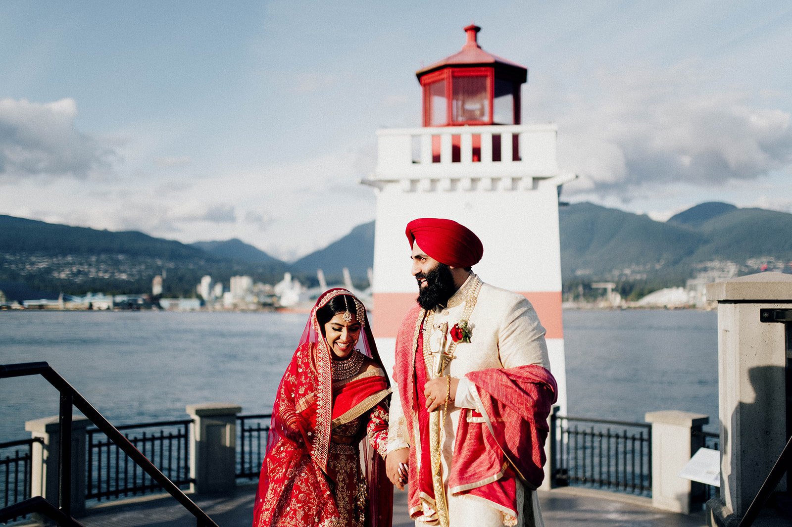 an Indian couple walks away from the lighthouse at brockton point overlooking the north shore in Vancouver BC.