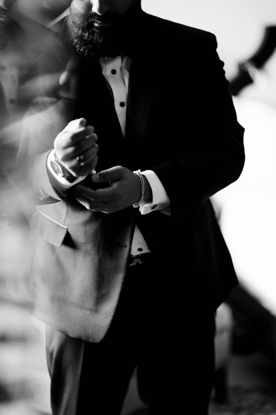 A stylish groom adjusts his cufflinks before his reception in Vancouver BC. 