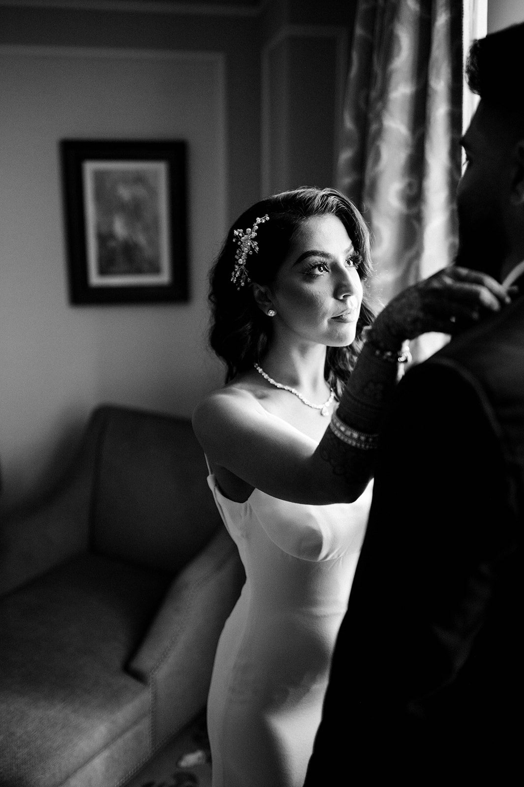 A bride adjusts her groom's collar before the head to their reception.