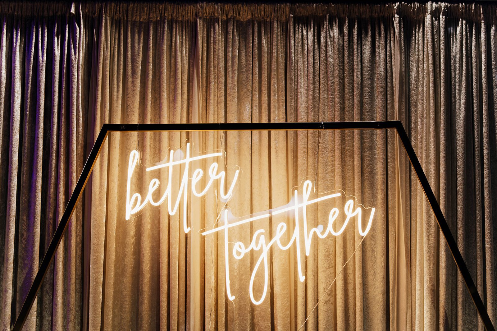 A yellow neon sign reads "better together."