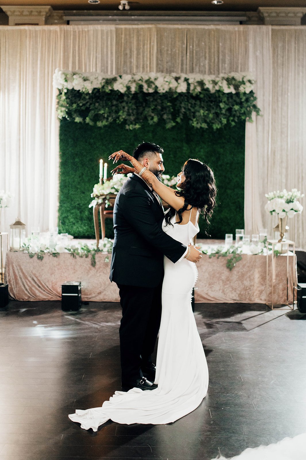 A bride and groom have their first dance in front of their head table.