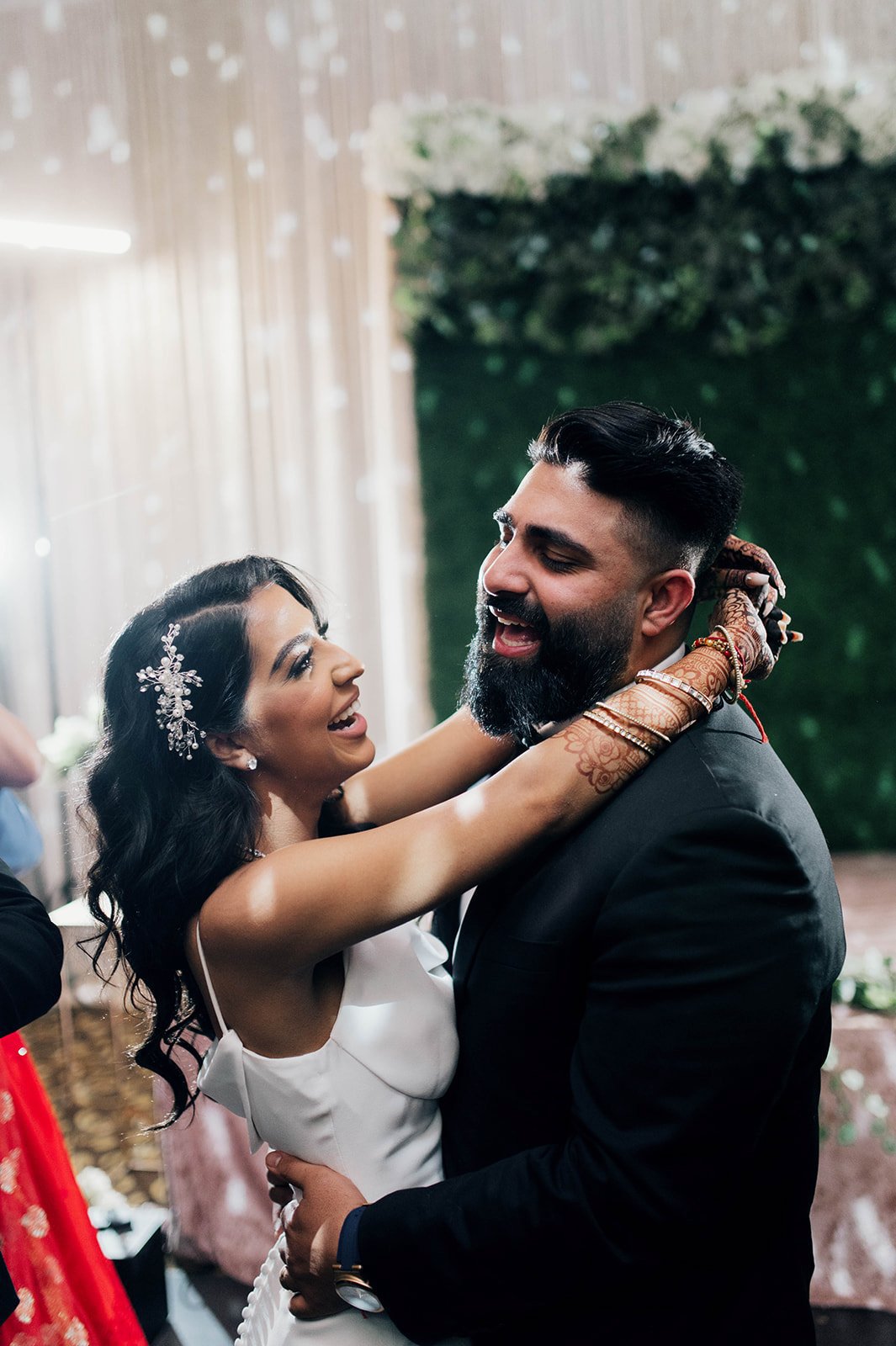 A bride and groom laugh as they dance their first dance.