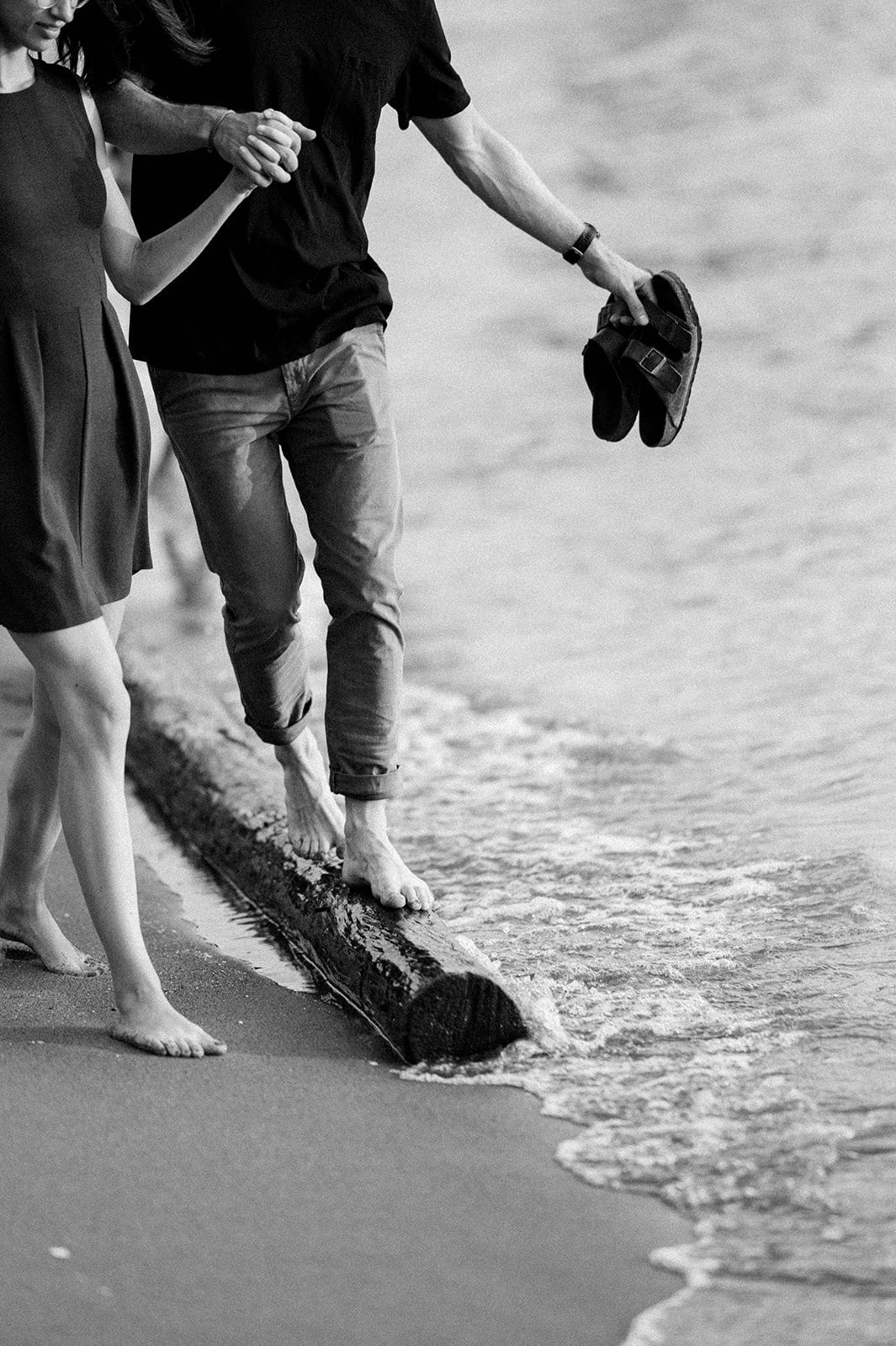 An attractive couple stroll on the beach at English Bay on a clear sunny day in Vancouver BC.