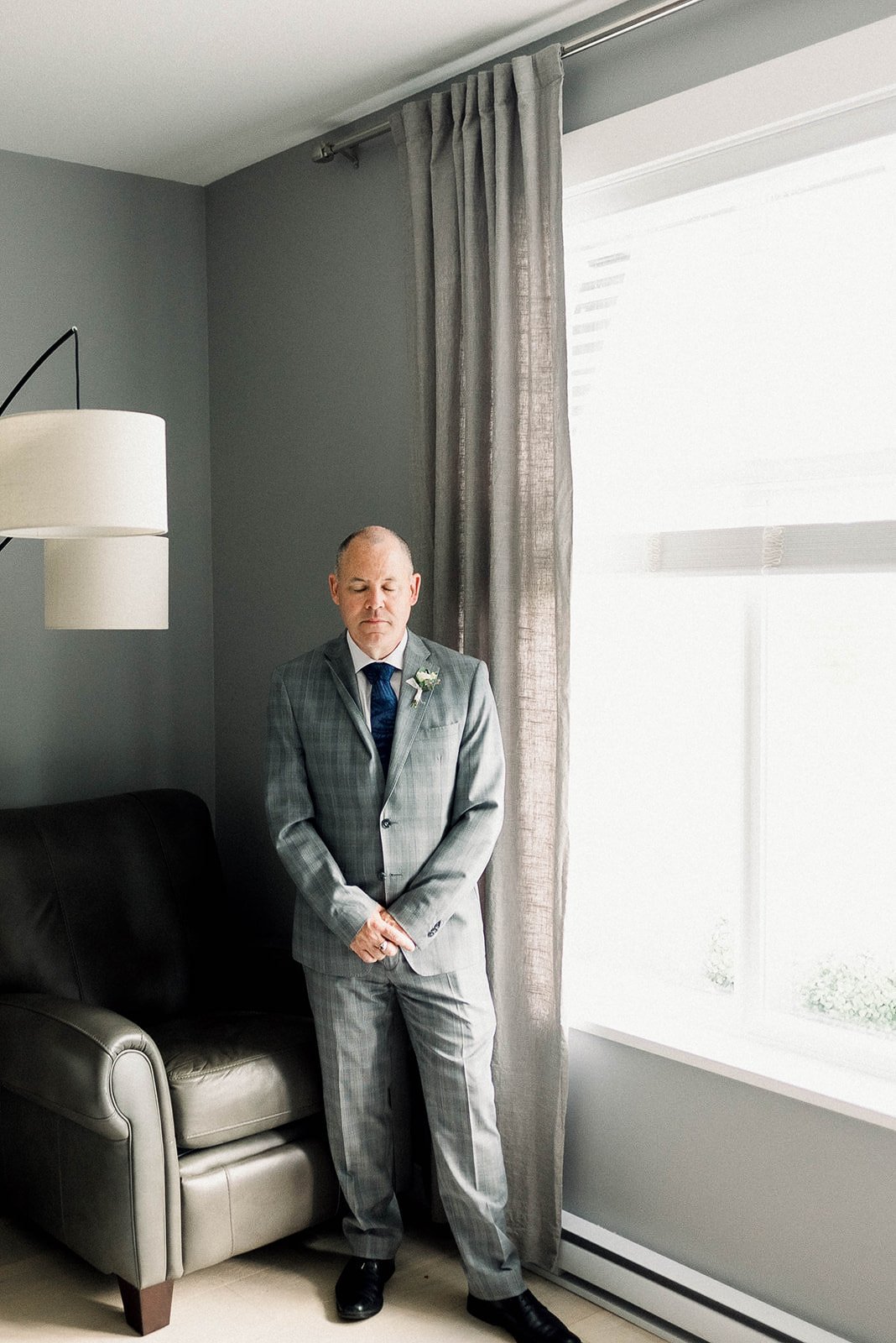 Groom in a grey suite on the morning of his wedding day in Vancouver, BC.
