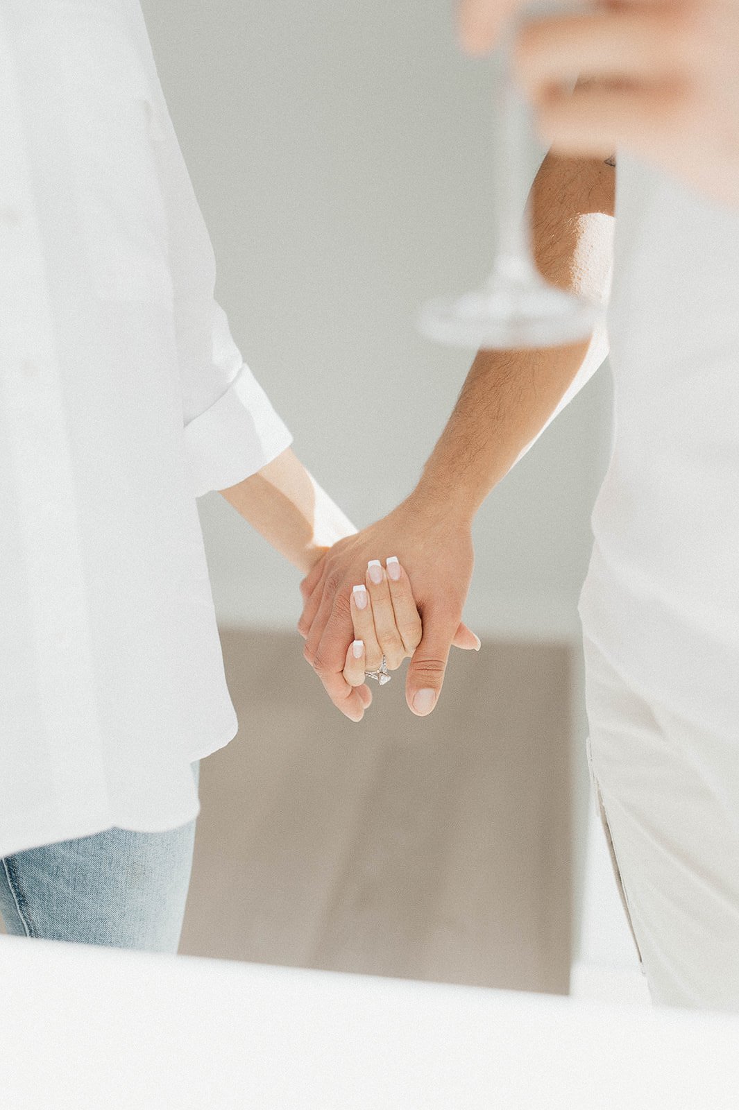 close up of couple holding hands in the apartment during their engagement photo session.