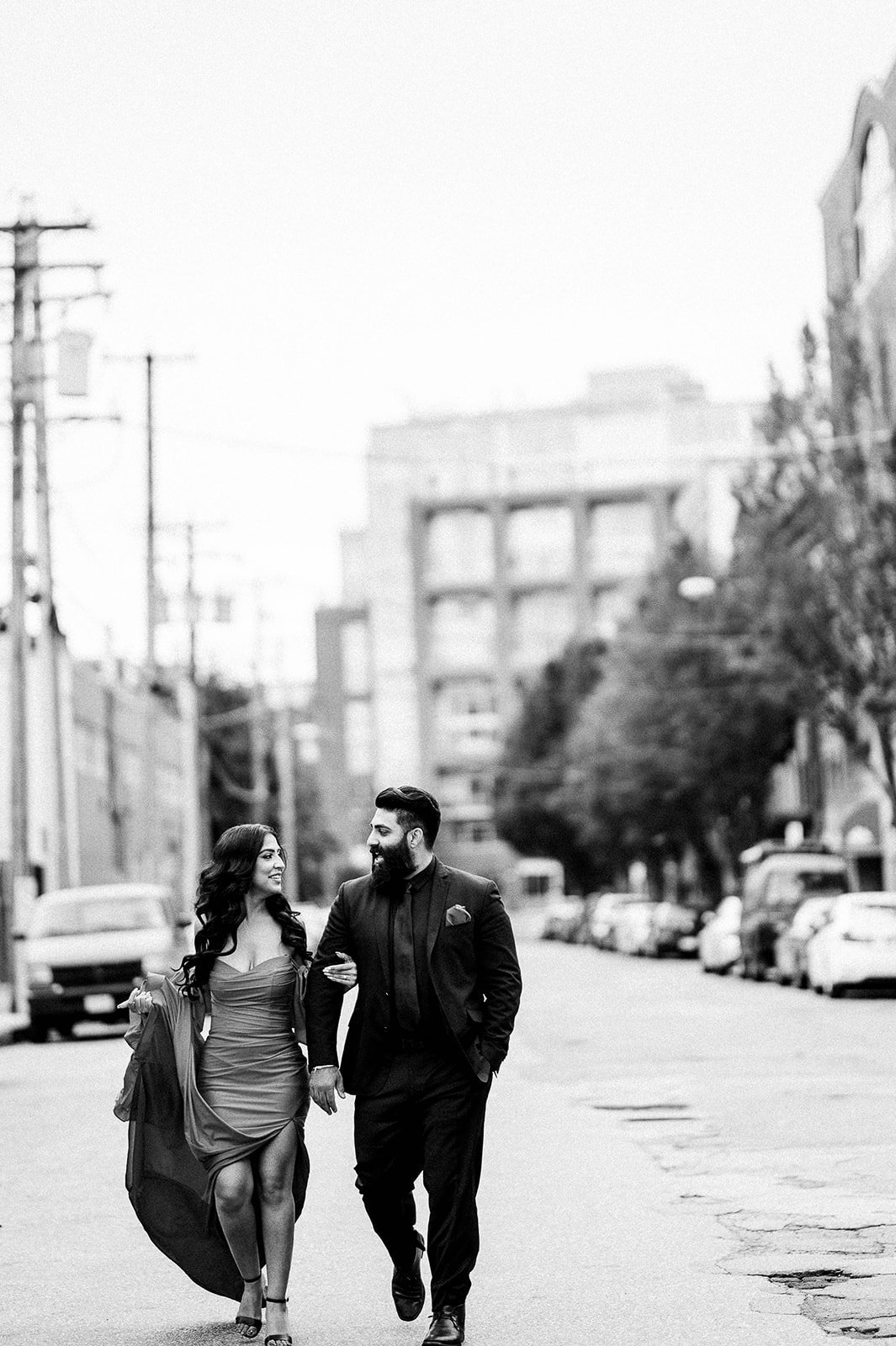 chic couple walking down the street in Railtown Vancouver, BC during their engagement session.