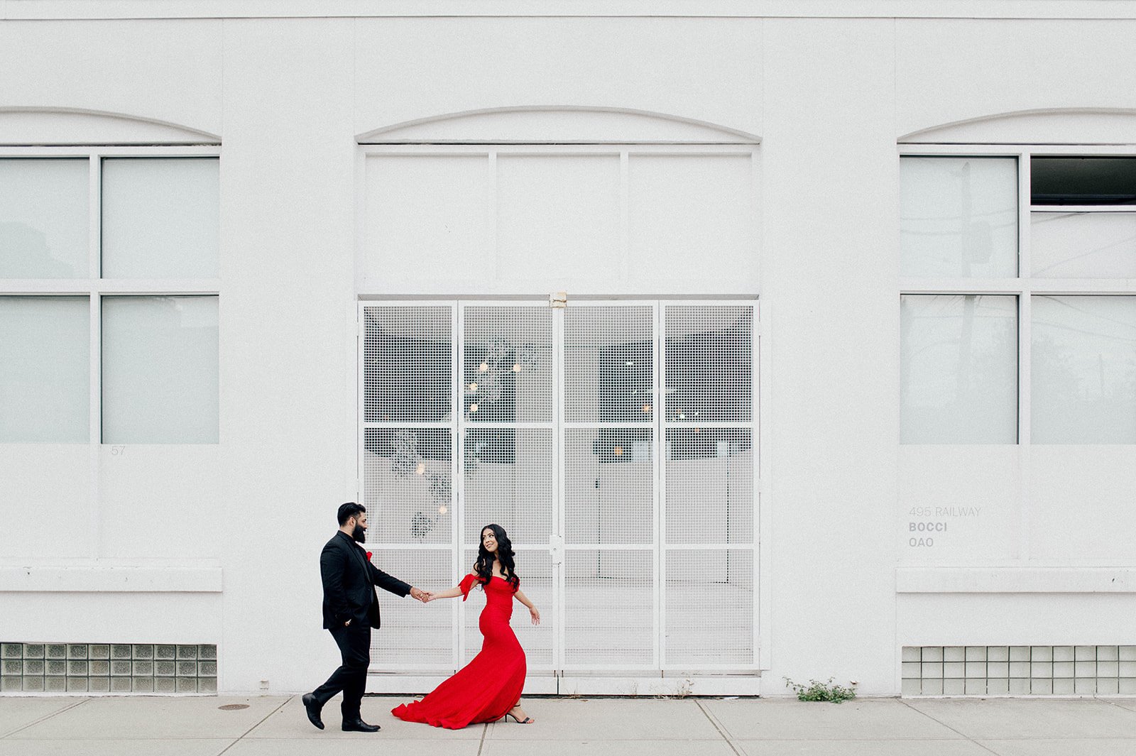 couple walking infront of a white building in Railtown Vancouver, BC. Beautiful Life Studios BC.