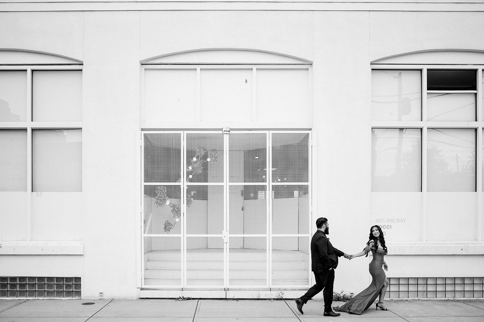 couple walking infront of a white building in Railtown Vancouver, BC. Beautiful Life Studios BC.