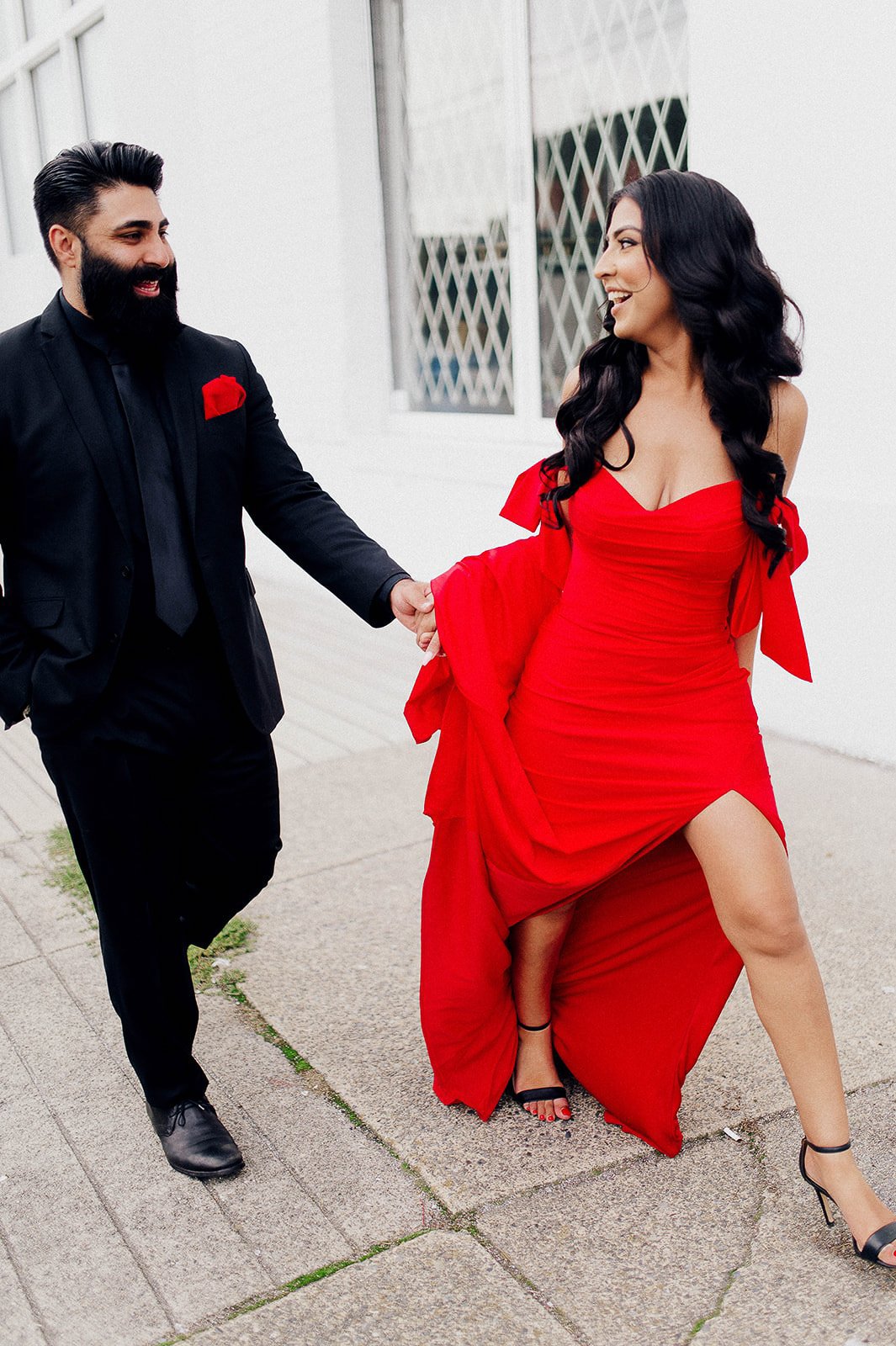 chic couple smiling at each other during their engagement session in Vancouver, BC