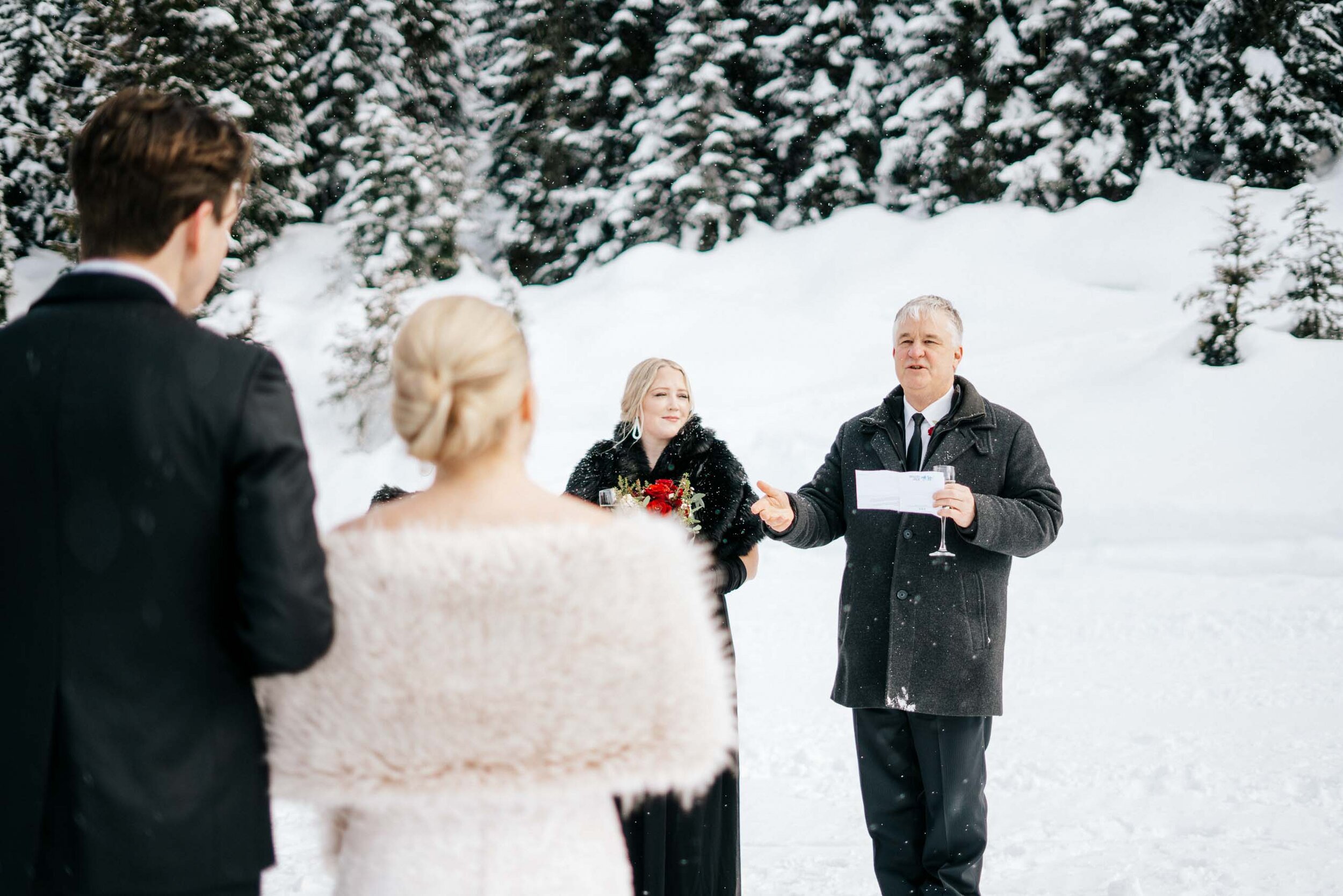 The brides father reads his toast to the bride and groom in the snow.